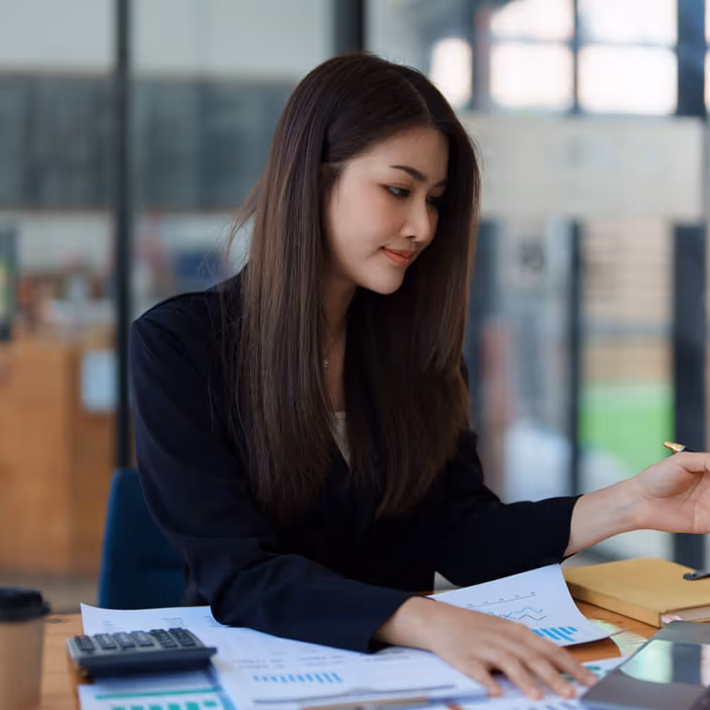 Professional reviewing trial defense documents and financial paperwork at a desk.