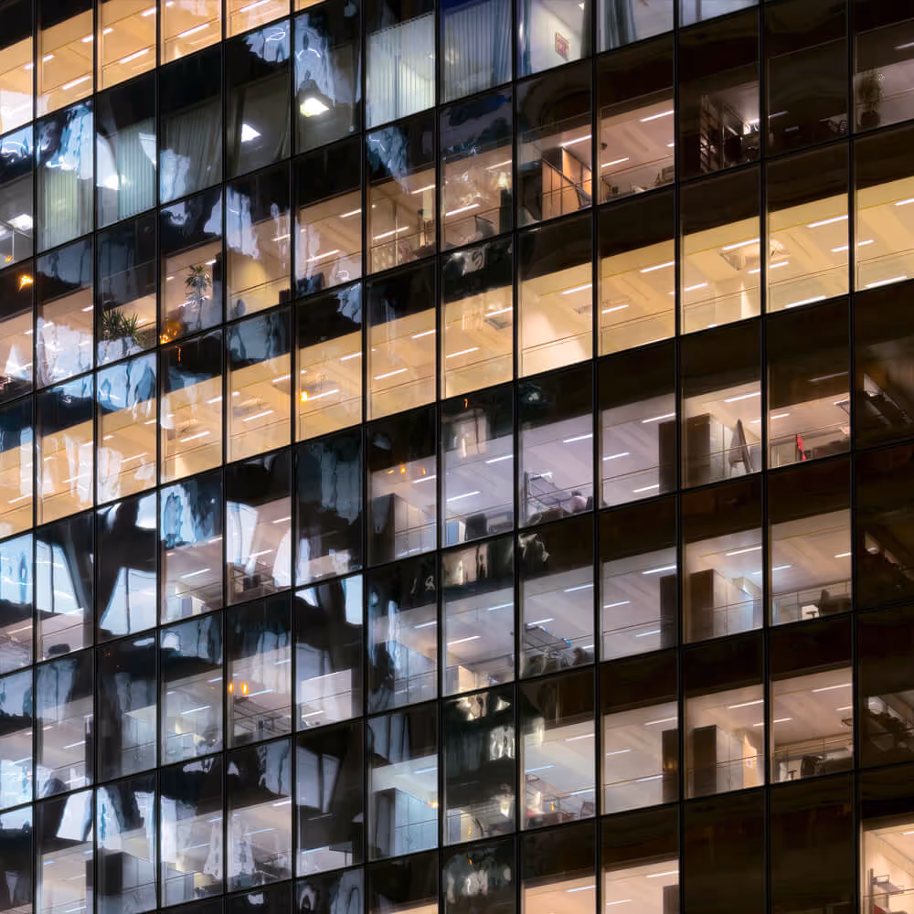 Office building windows at night, representing a directory of law firms and legal professionals.