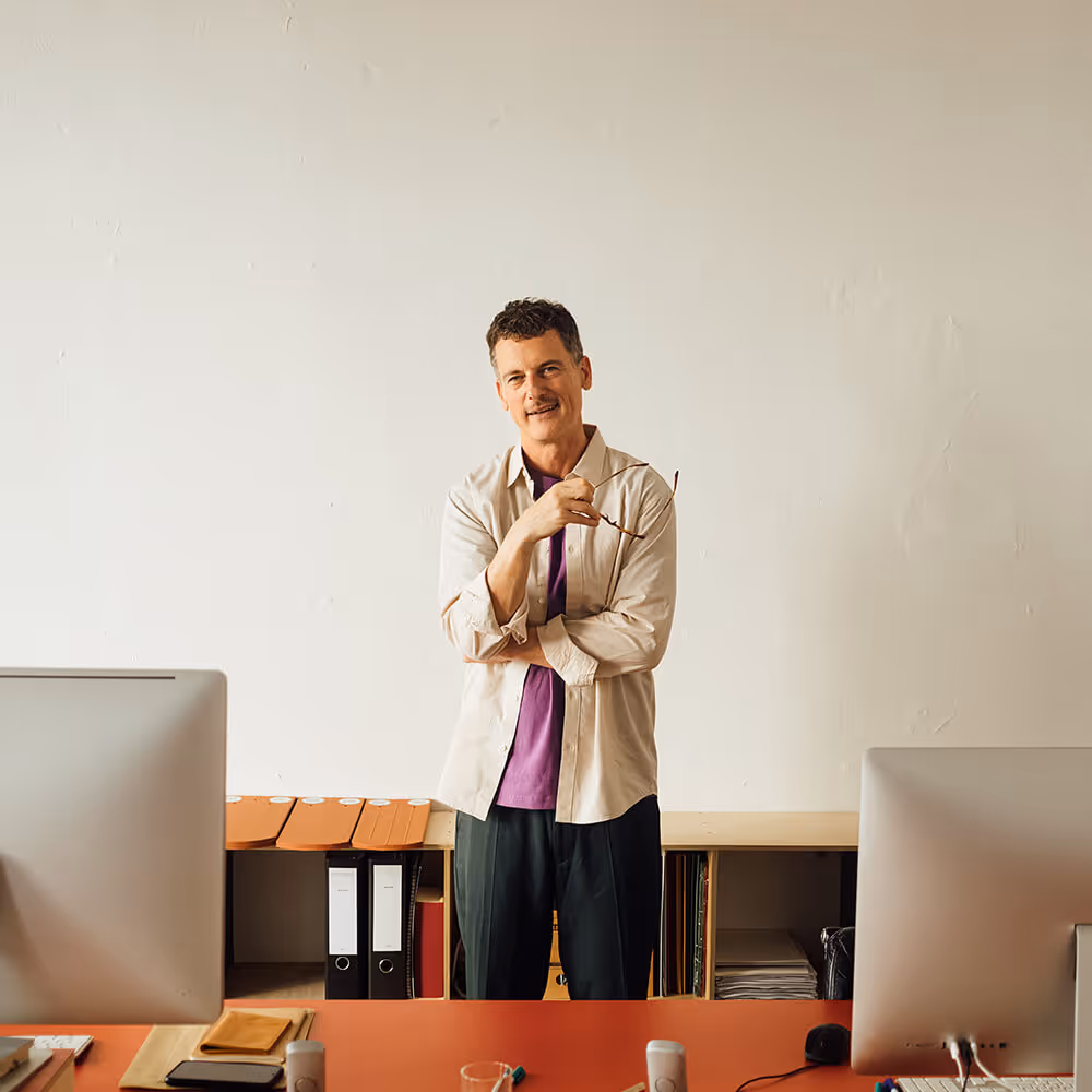 Home-based business owner standing in a workspace, representing small business operations and legal support.