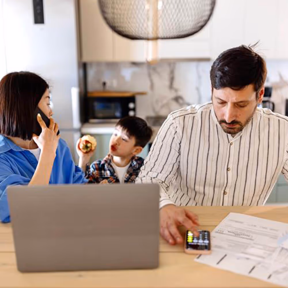Family reviewing household bills and expenses at a kitchen table, representing financial stress and consumer legal concerns.