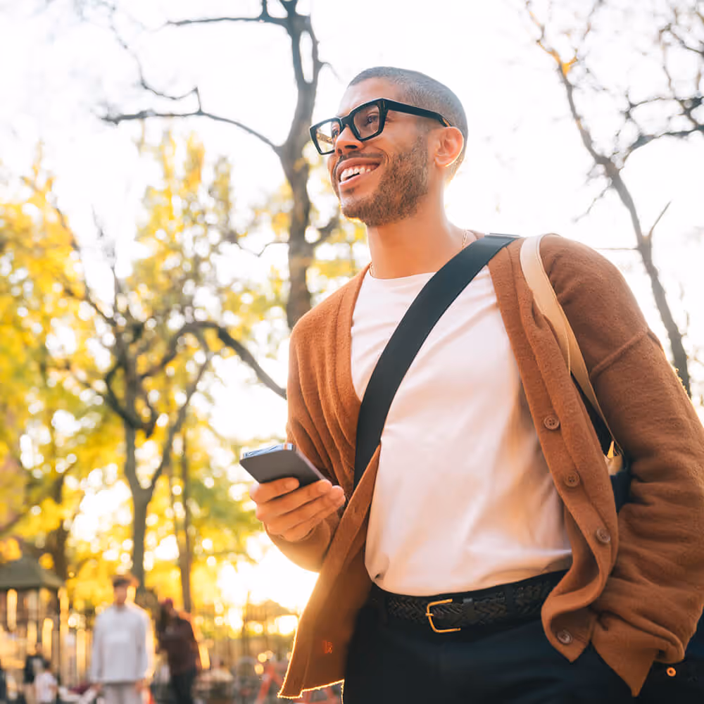 Person walking outdoors while using a phone, representing convenient access to legal support on the go.