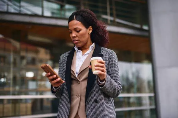 Professional receiving real-time identity theft alert notification on smartphone while at work