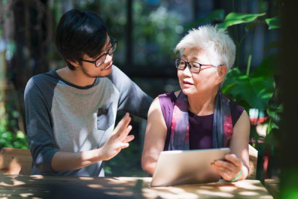 estate planning discussion with mother pointing to tablet screen when talking with her adult son