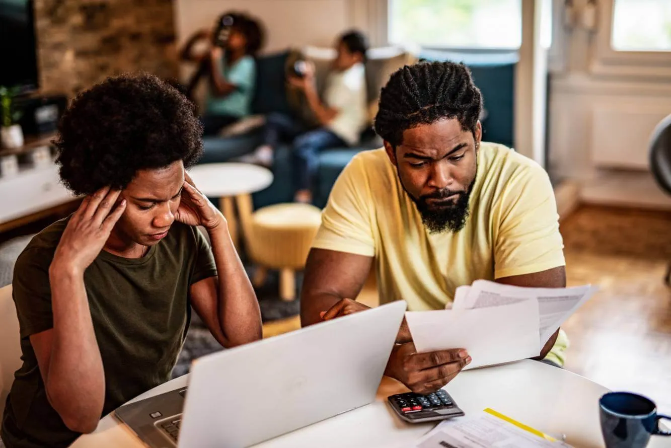 couple looking at their household bill and stressed by debt