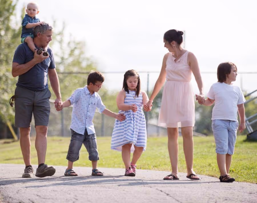 Couple with 4 small children taking a walk & all holding hands