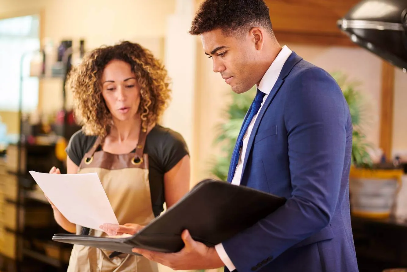 small business shop owner talking to her lawyer and reviewing legal documents