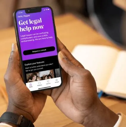 Man holding his iPhone and looking at the LegalShield Get Legal Help Now home screen
