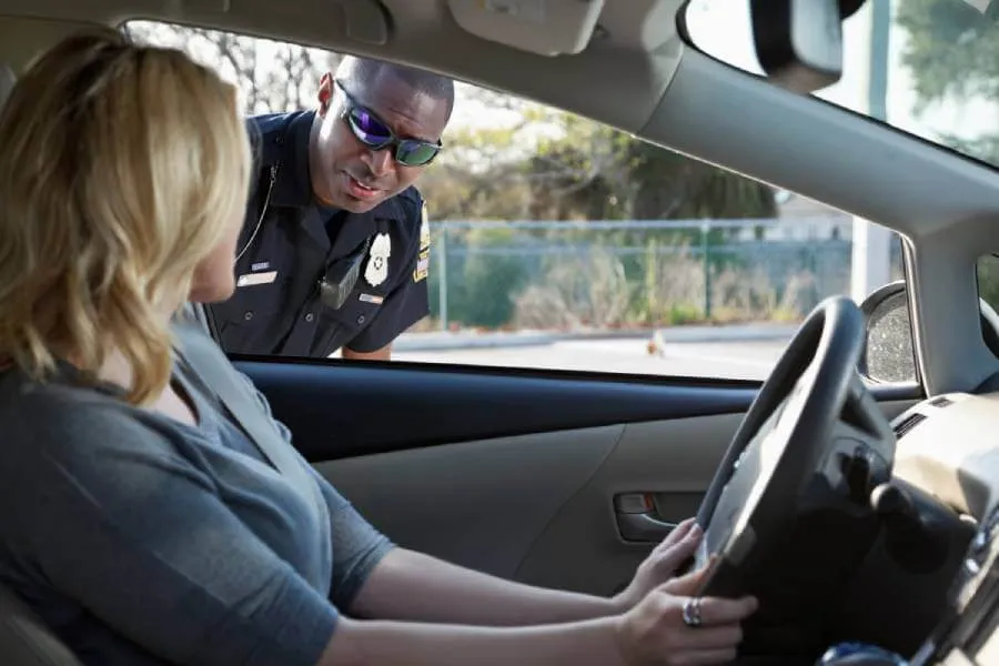 Woman driving getting a traffic ticket from a police officer