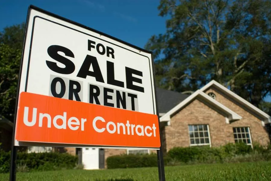 sign reading home under contract in front of house for sale