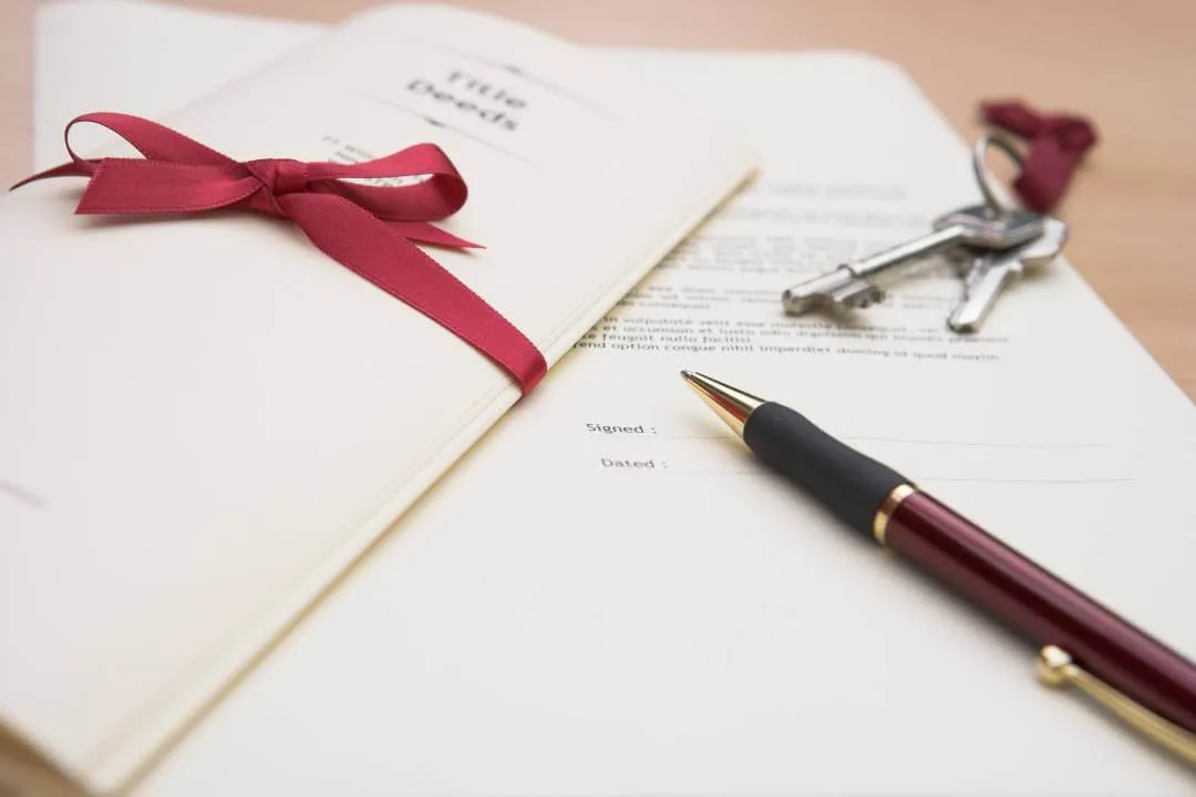 property title deeds, keys and ink pen