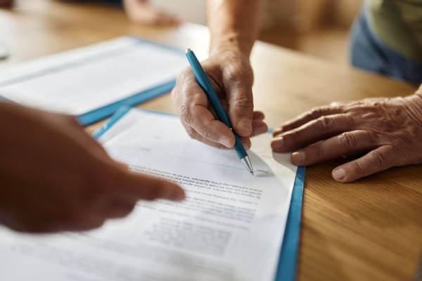 man signing property deed tranfer