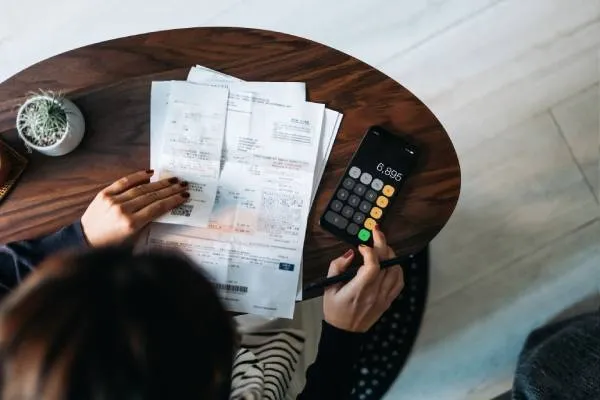 Woman using calculator to deal with financial paperwork
