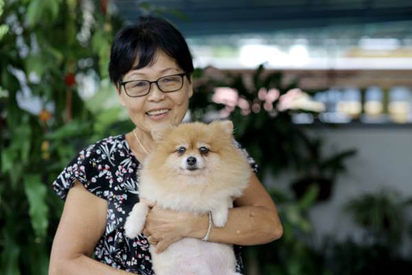 Woman holding her cute Pomeranian dog