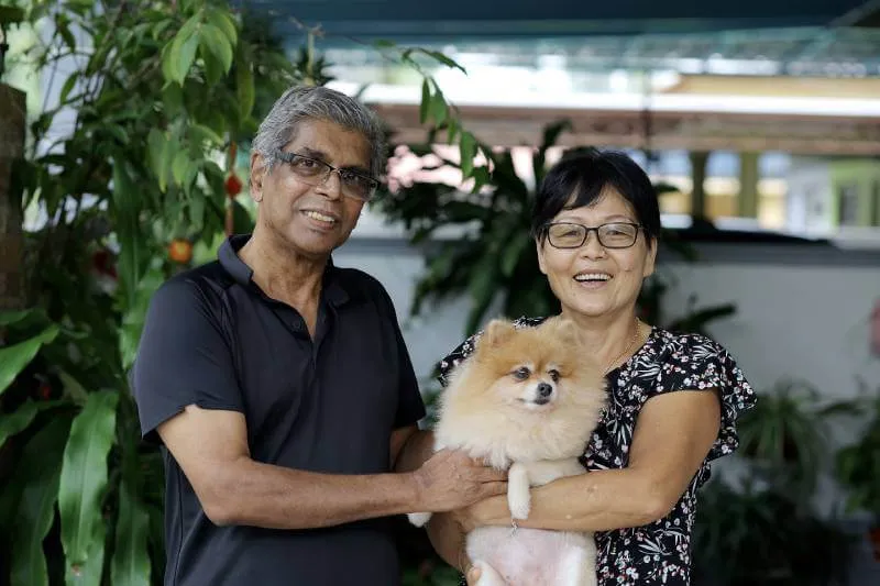 Husband and wife posing with their pet Pomeranian dog who is included in their estate plan