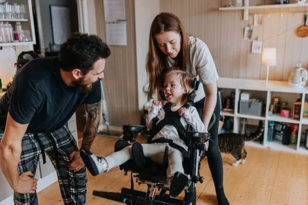 Mother and father helping young child in a wheelchair