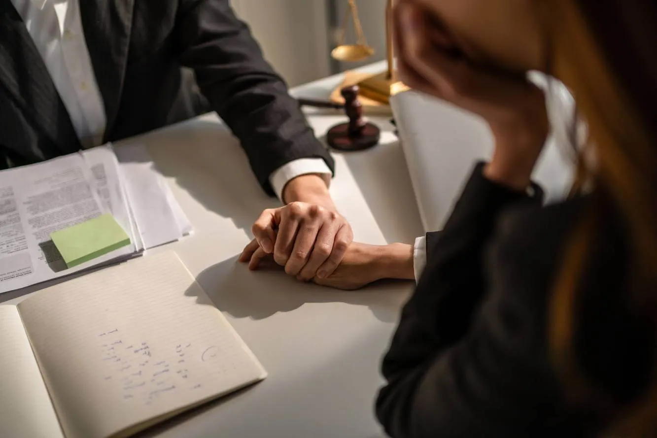 lawyer holding the hand of a client during a contingent beneficiary discusson