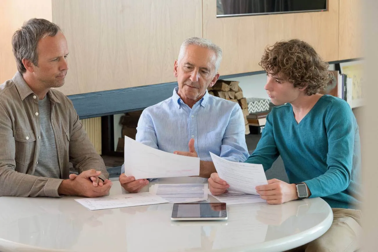 grandfather discussing contingent beneficiary designation with his grandson as his son looks on