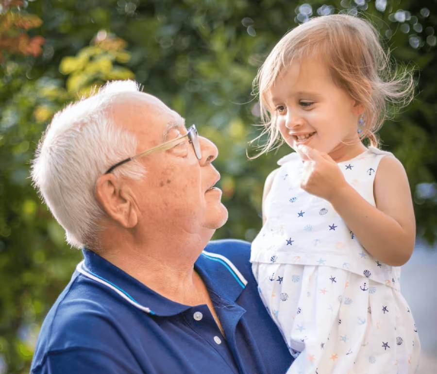 Grandpa holding his young granddaughter outside|Elderly woman holding a pie|Elderly woman holding a pie