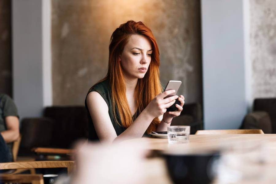 Female employee looking at social media on her smartphone