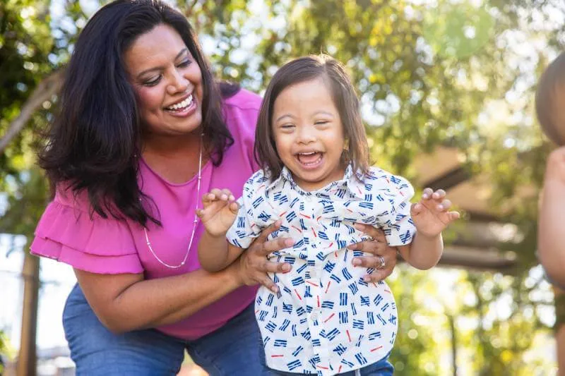 Mother playing outside with young daughter with Down's Syndrome