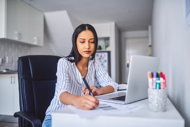 Woman working from home on Employee Handbook