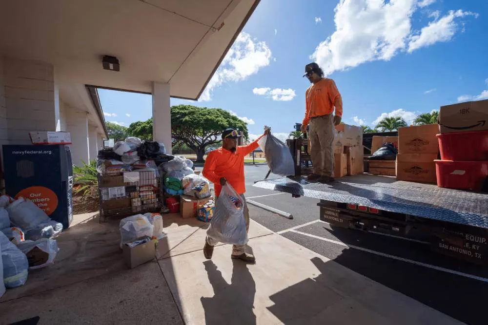 Pacific Missile Range Facility contractors Albert Niau-Kanahele and David Planas move donations to be shipped to Maui to help wildfire victims, at Pacific Missile Range Facility, Hawaii, Aug. 13, 2023. PMRF, located on the island of Kauai, began collecting donations in the wake of the devastating wildfires on Maui. (U.S. Navy photo by Lisa Ferdinando) Taken on Aug. 13, 2023