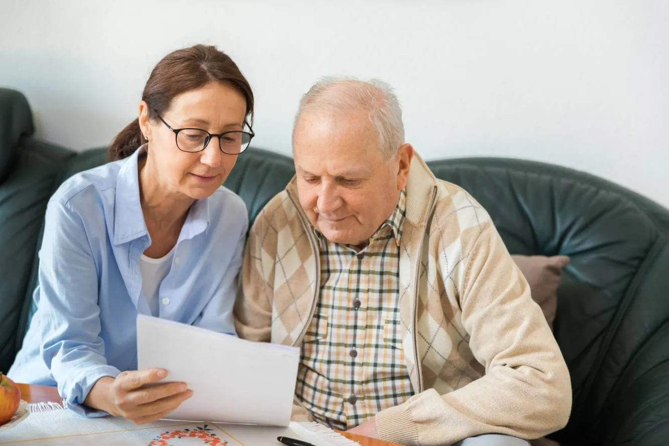 woman explaining the difference between a primary and a contingent beneficiary to an elderly man