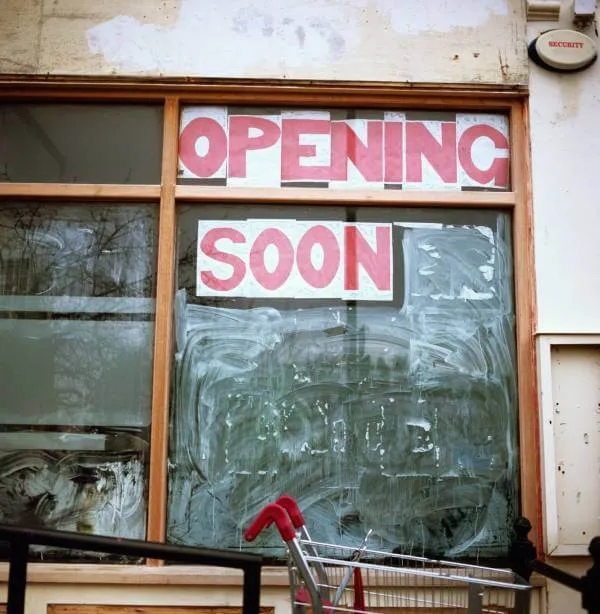 small business building with an opening soon sign in the window