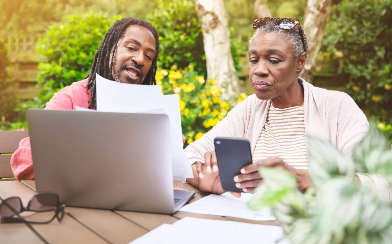 Man and older woman looking at estate tax documents at an outside table