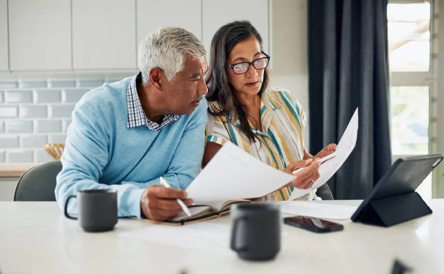 Mature couple reviewing documents to decide what to include in their Will