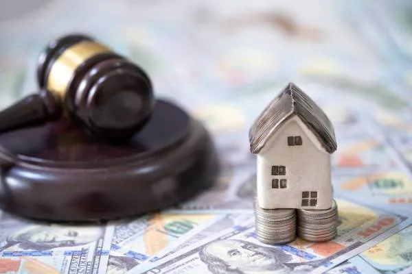 judge's courtroom gavel next to money and a toy house to represent eminent domain litigation