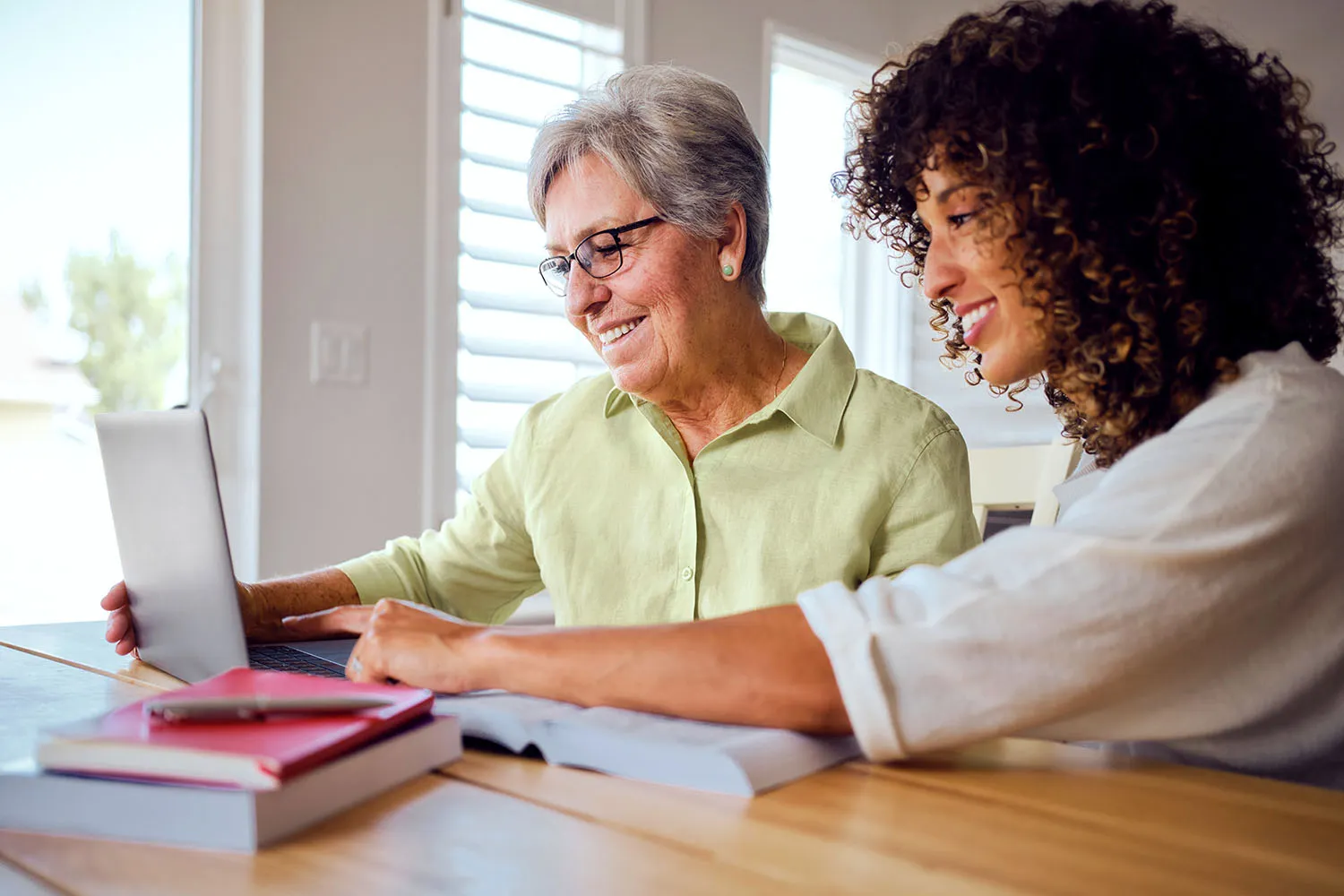 Two women on a laptop exploring living trust cost.