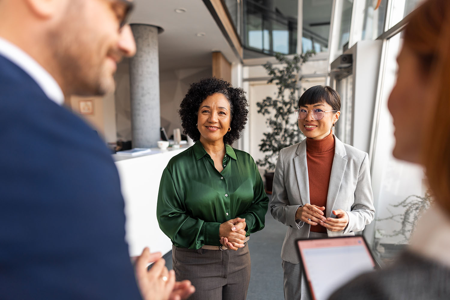 Four people in conversation; two in the foreground facing away, having a conversation about PLLCs vs. LLCs.