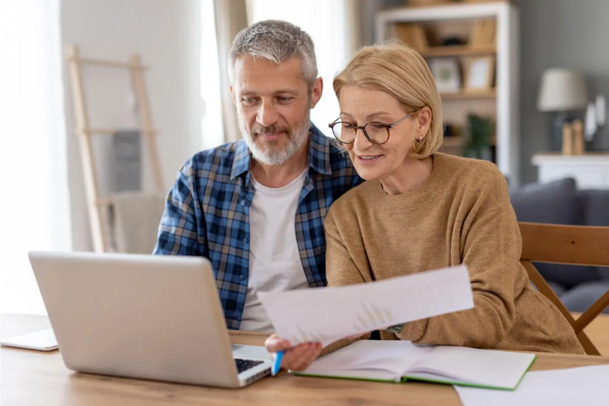 A couple with a laptop and documents planning their estate.