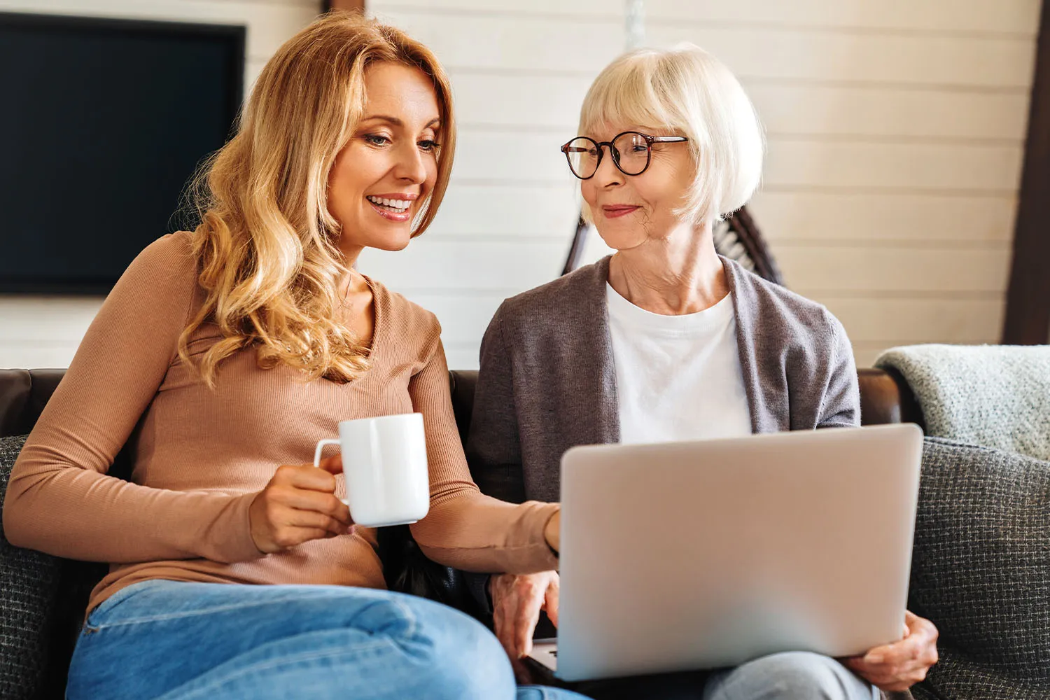 Two women reviewing documents on a laptop