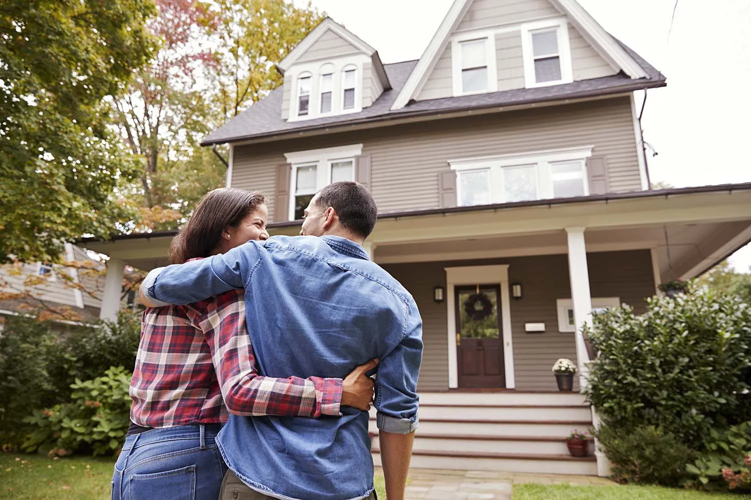 A happy couple in front of their new house