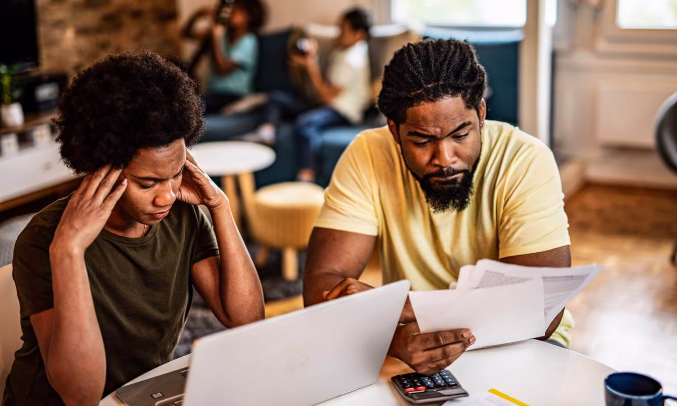 couple looking at their household bill and stressed by debt