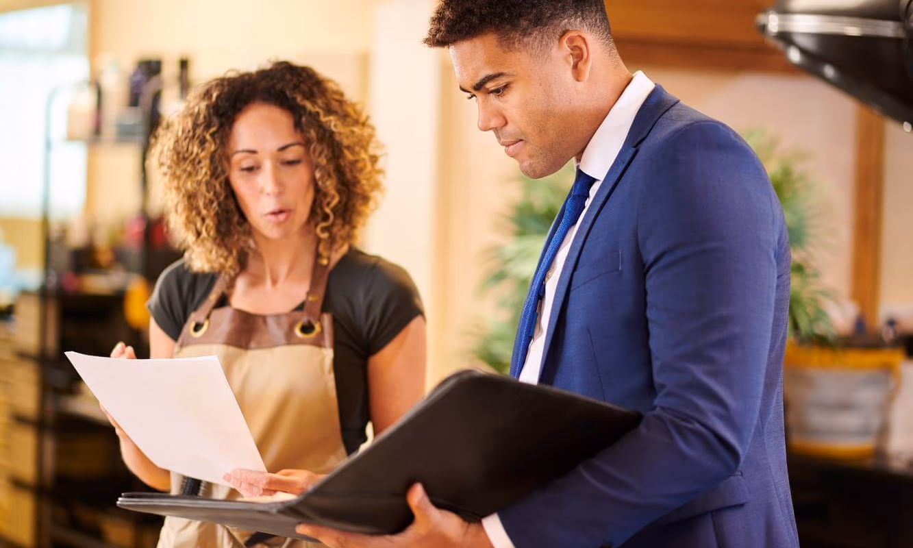small business shop owner talking to her lawyer and reviewing legal documents