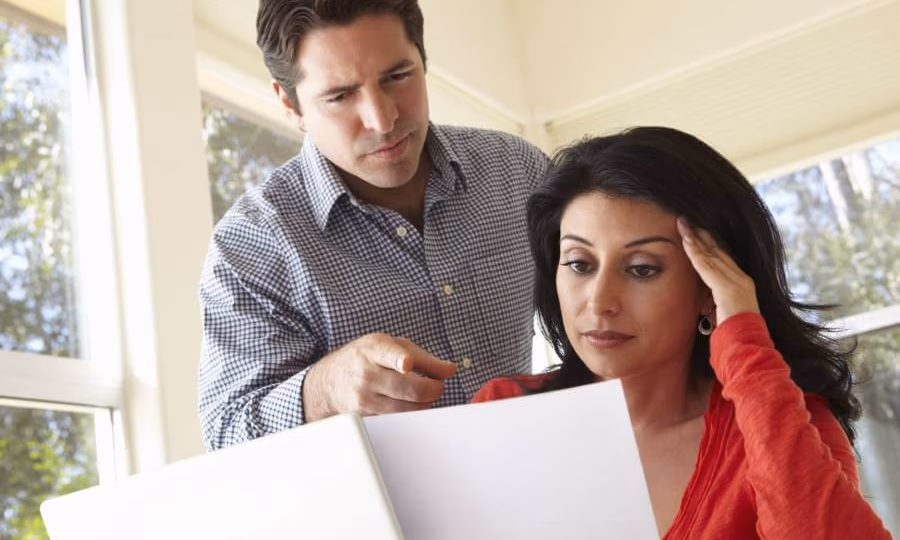 Stressed man and woman looking at bankruptcy document