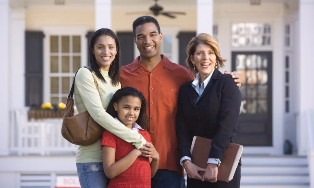real estate attorney standing with family of 3 in front of their home