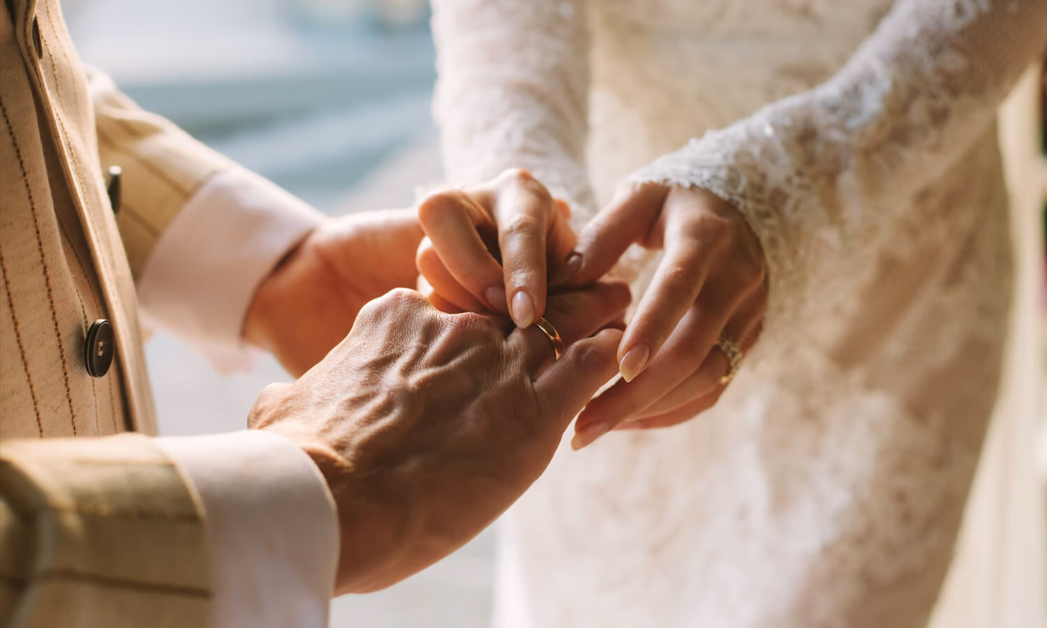 Bride putting ring on groom's finger