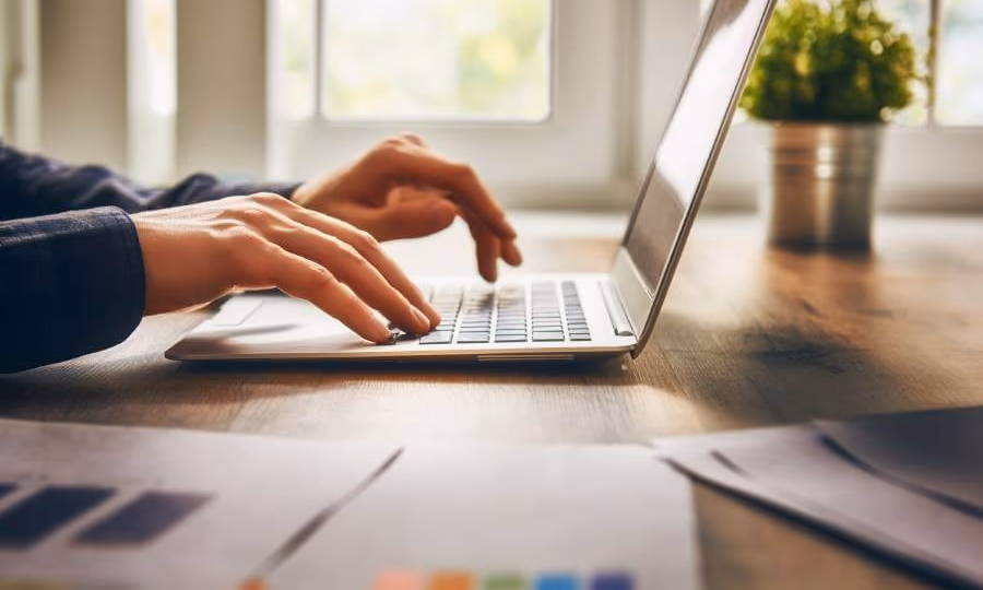 Small business owner typing on a laptop