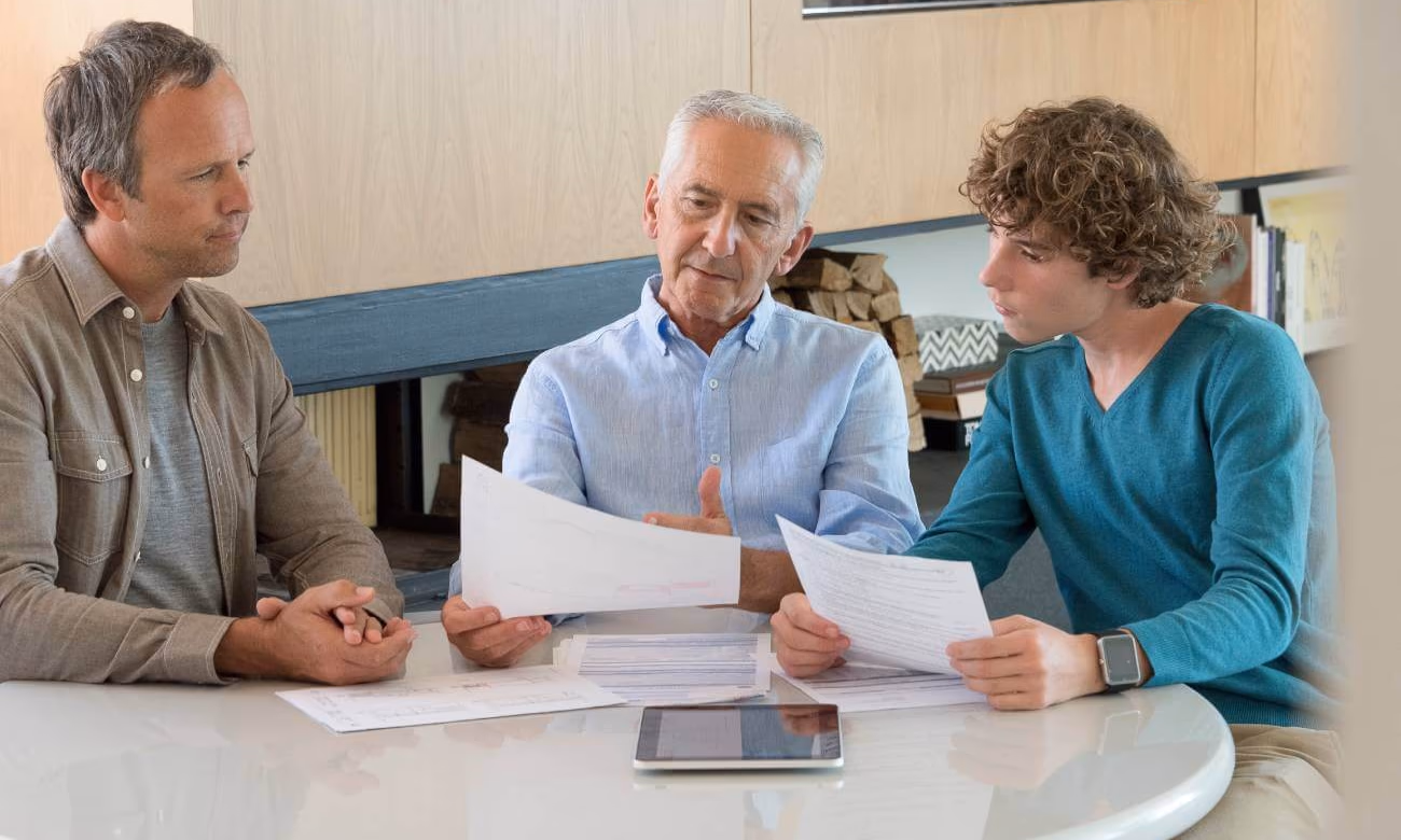grandfather discussing contingent beneficiary designation with his grandson as his son looks on