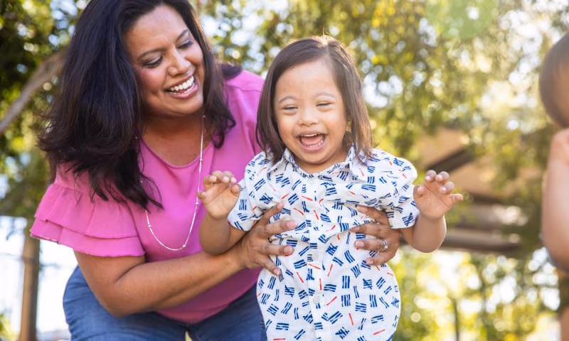 Mother playing outside with young daughter with Down's Syndrome