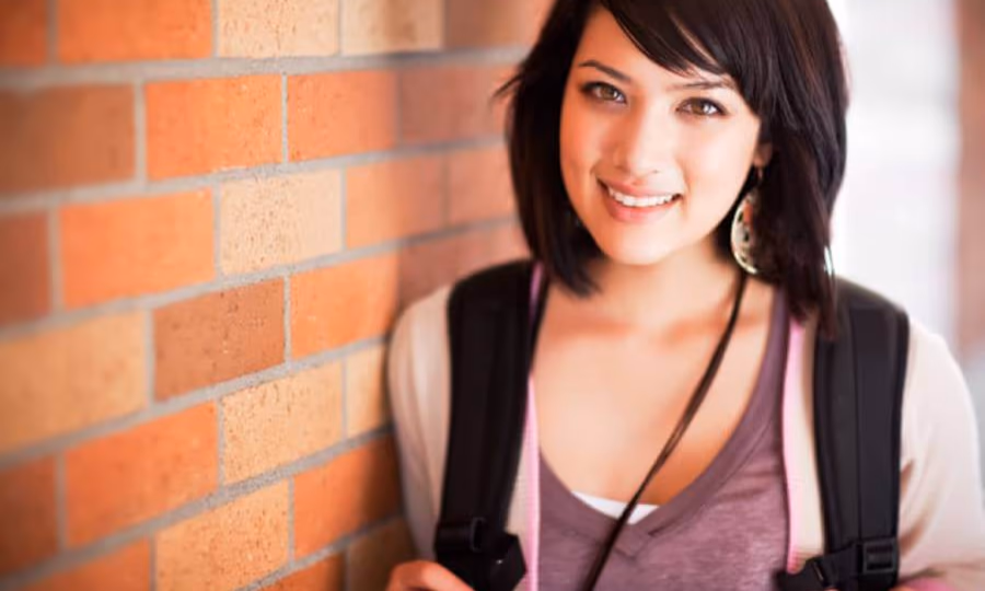 College student leaning on a wall