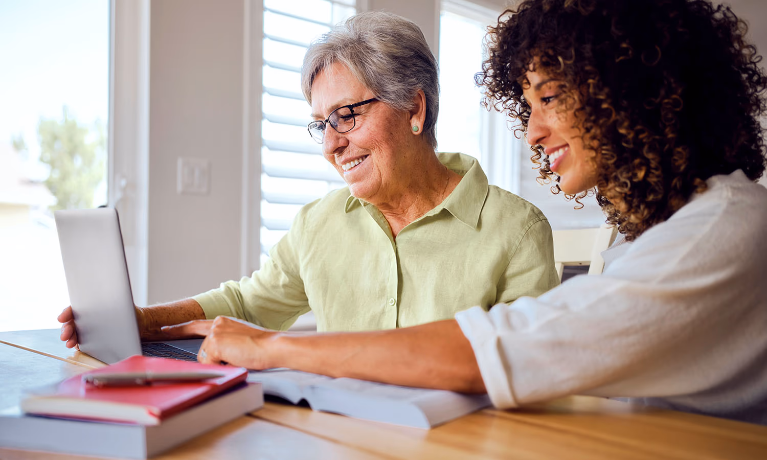 Two women on a laptop exploring living trust cost.