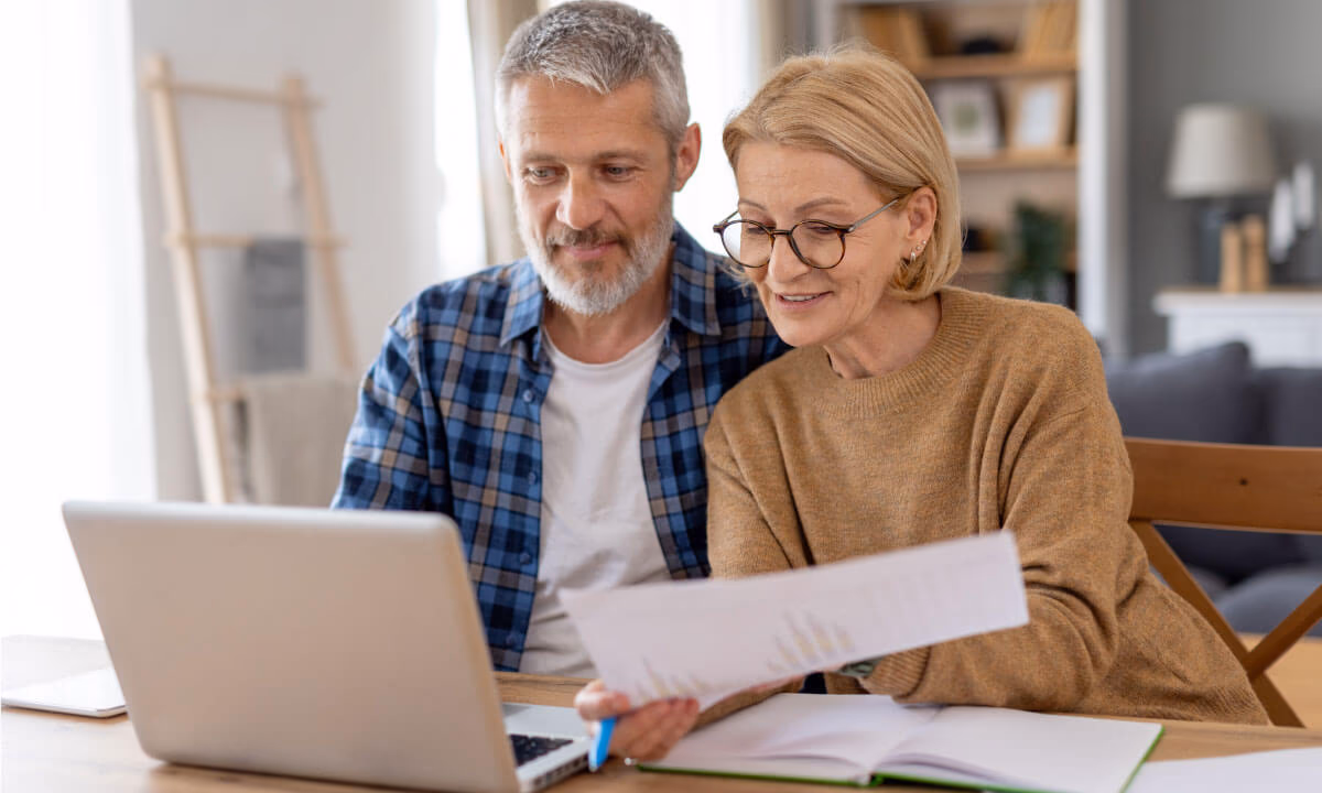 A couple with a laptop and documents planning their estate.
