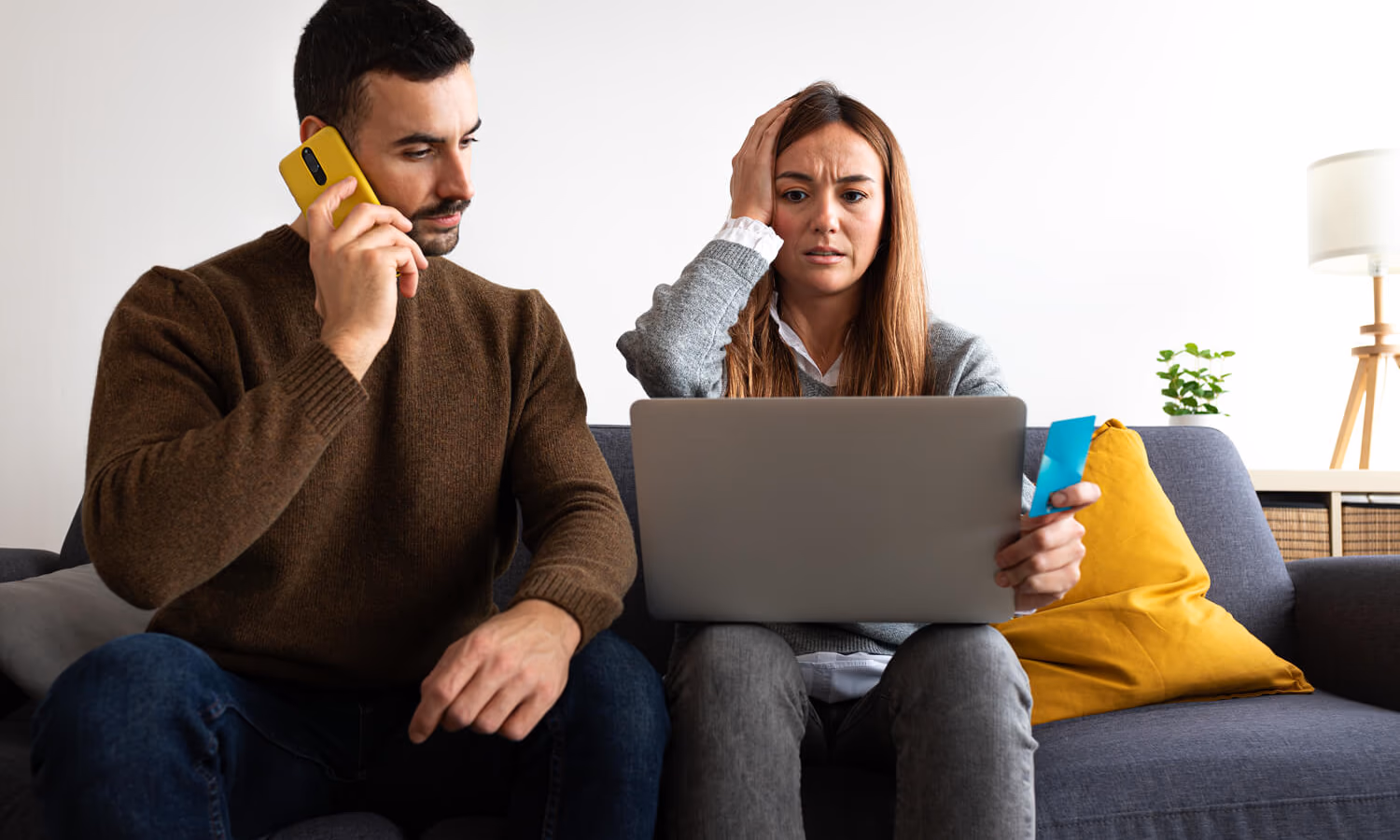 Young-couple-having-financial-problems-calling-bank