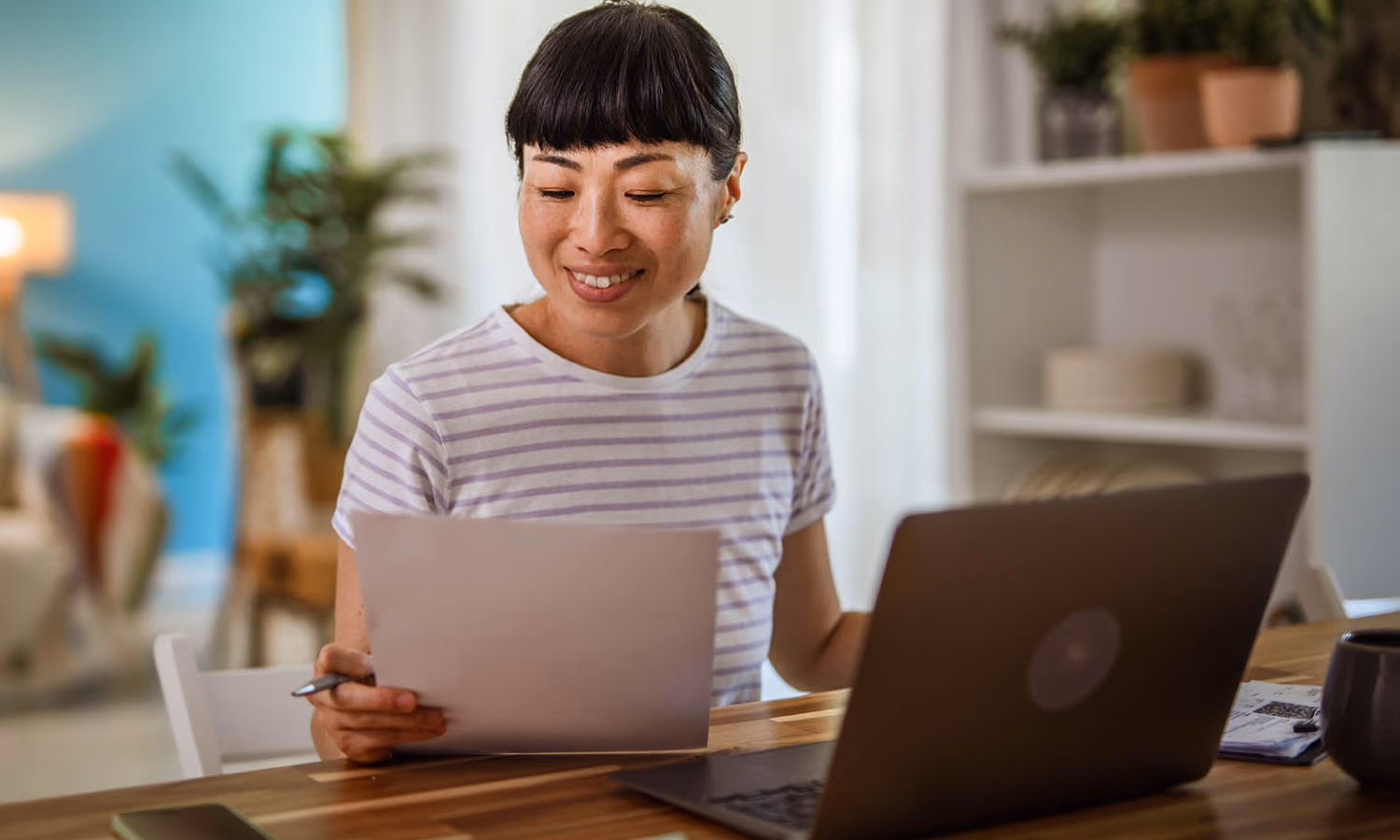 A woman sitting at a table reviewing a contract.