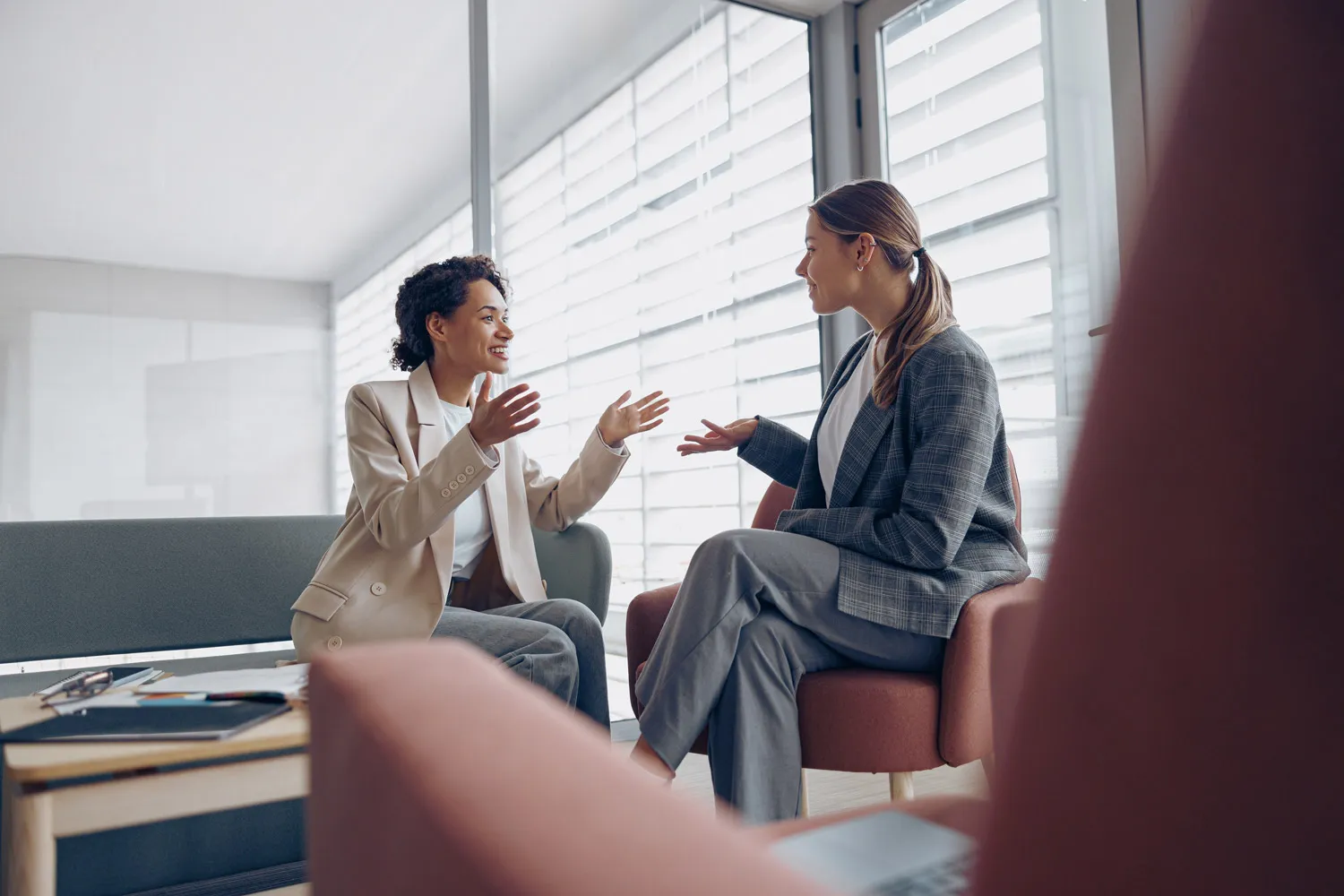 Two professional women talking in an office.